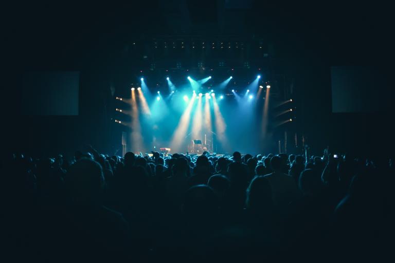A concert stage with a large crowd enjoying a live music performance