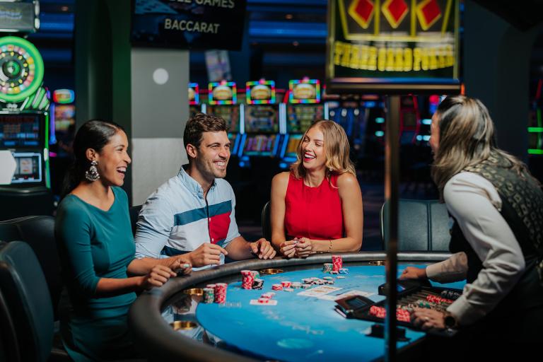 Several people gathered around a poker table