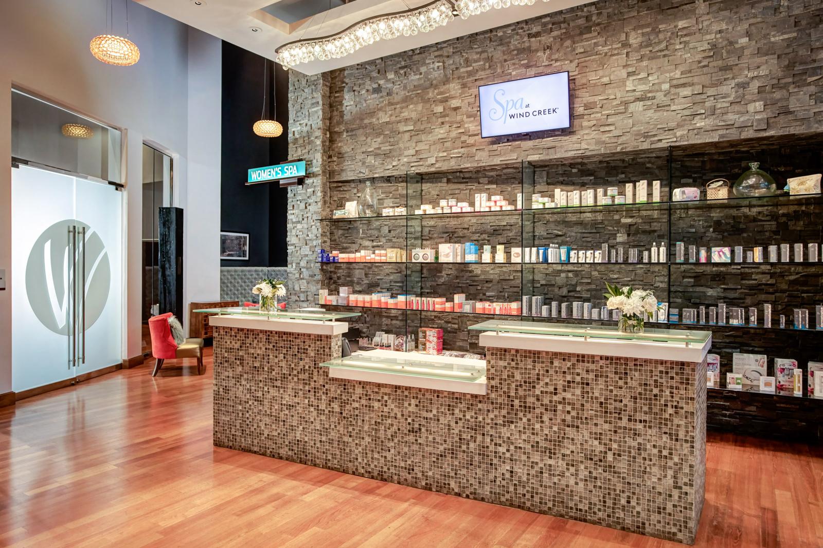 Receptionist desk for the Spa at Wind Creek showcasing the products they use and the entrance to the Women's Spa