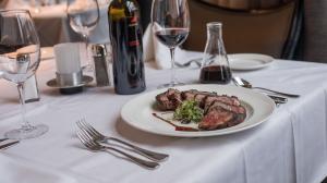 A plate of steak and wine