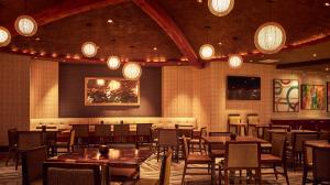 A warmly lit restaurant dining area with tables and chairs