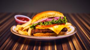Classic cheeseburger and french fries served with a side of ketchup 
