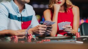 A man and a woman consider their cards over a hand of poker at Wind Creek Curaçao