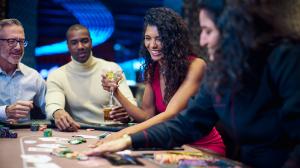 A group of people gathered around and engaged in a casino table game.