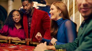 A group of people gathered around and engaged in a casino table game.